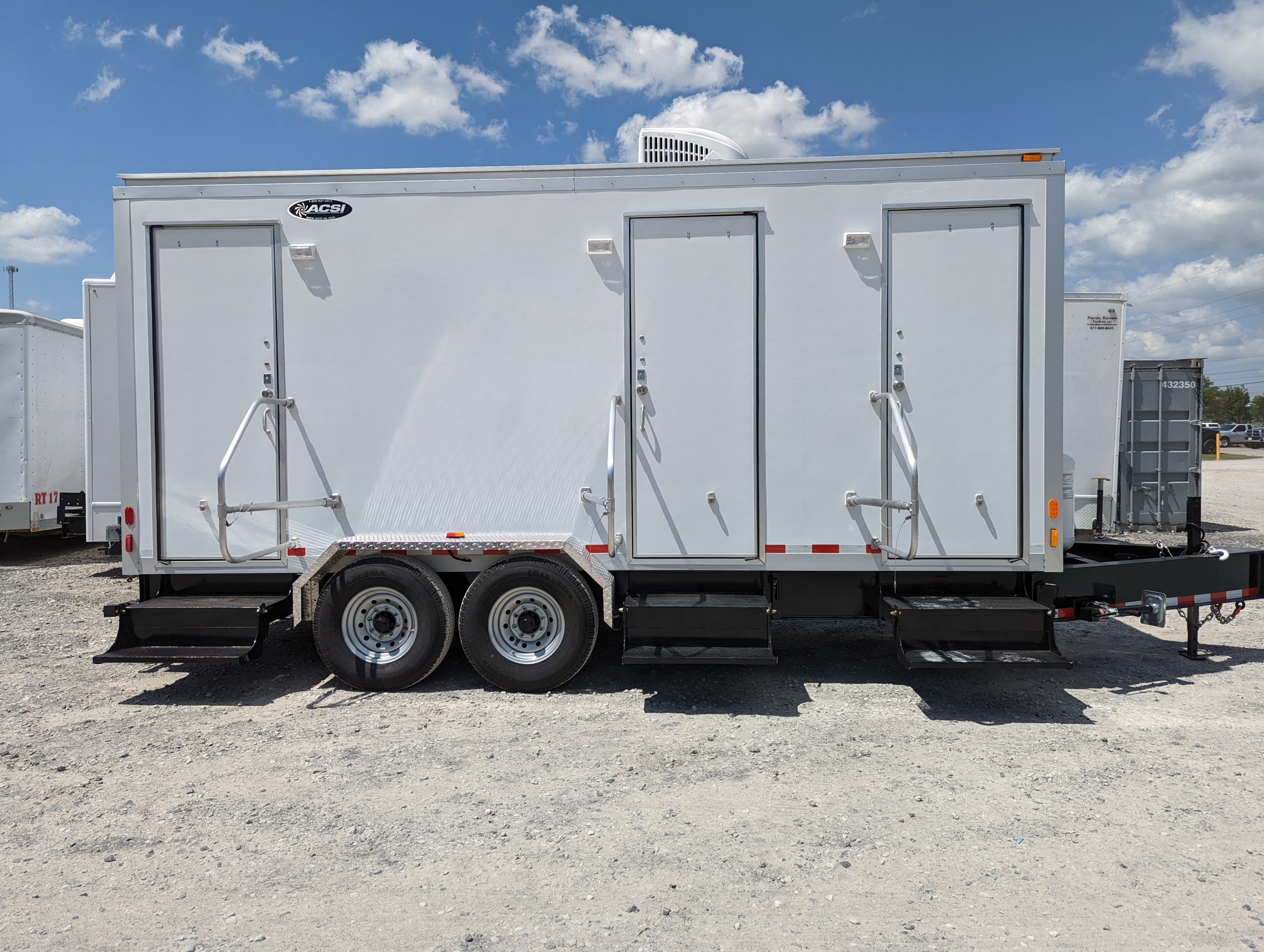 Event restroom trailer equipped with private stalls, running water, and interior lighting.