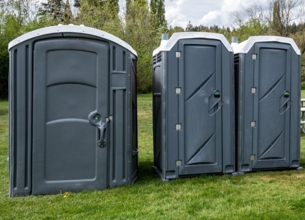 Single portable toilet placed outdoors for temporary sanitation needs.