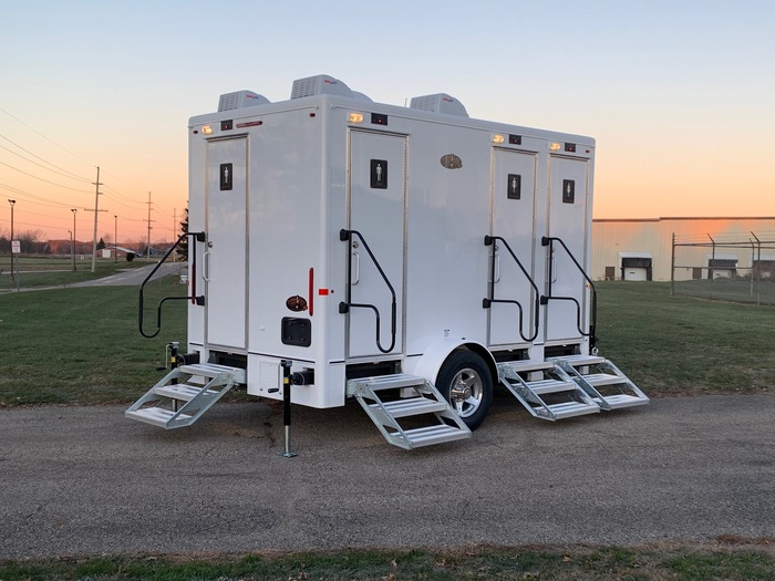 Multi-door restroom trailer with sturdy stair access and service-ready hookups.