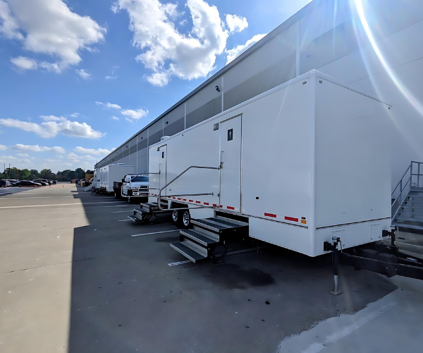 Modern restroom trailer rendering with clean lines and elevated entry platforms.