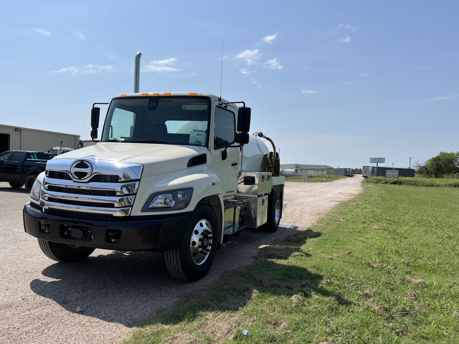 Aerial view of septic service trucks staged for dispatch at an operations yard.